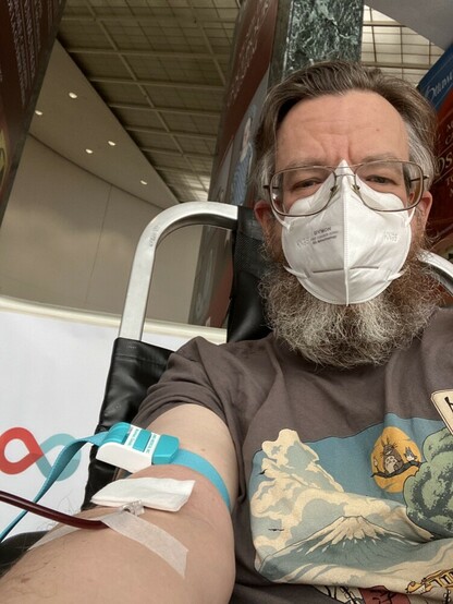 Selfie of me donating blood with a mask on.