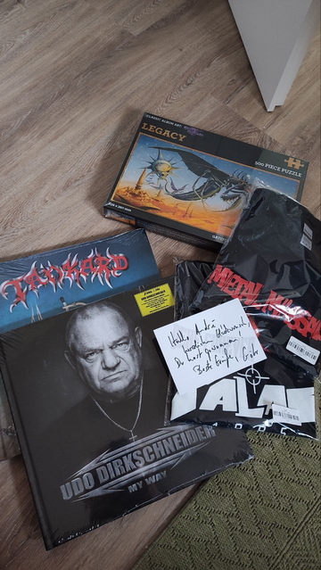 Foto: Bandshirts, CDs/Earbooks, ein Puzzle (wtf!? 😄) zu Praying Mantis' Legacy-Album und Grußkarte von Götz Kühnemund