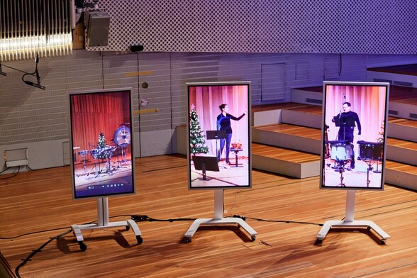 Musicians in Sweden being shown on LCD screens on stage in Berlin. 