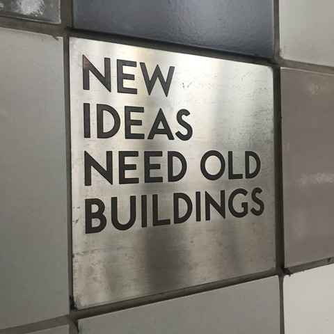 “New ideas need old buildings” tile at Dufferin Station in Toronto, Canada.