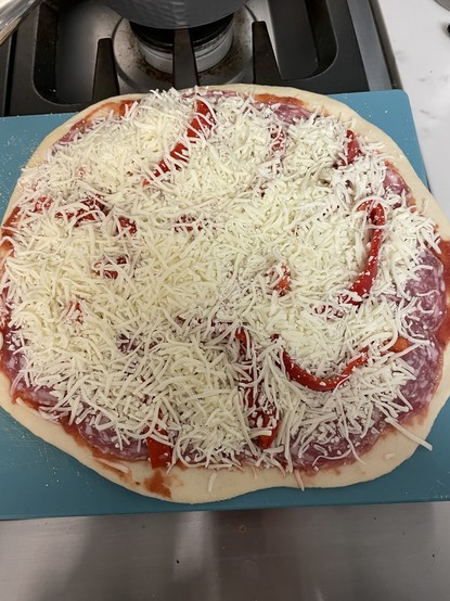 Unbaked pizza with lots of shredded mozzarella on top.