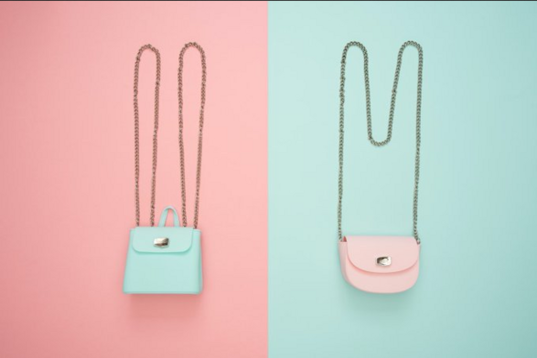 Light blue purse on a pink background and pink purse on light blue background. Both bags with long straps
