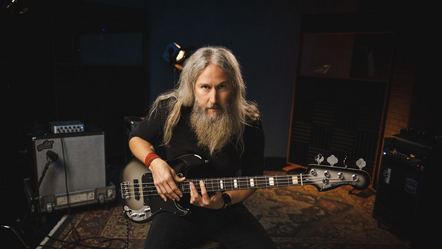 ChatGPT Summary:
This article introduces Fender's new Troy Sanders Precision Bass, a signature bass guitar designed by Troy Sanders of the band Mastodon. The instrument features a three-tone sunburst "jazzed-up vintage" design, an alder body and maple neck, and dual custom flat-pole, split-coil pickups with a reconfigured preamp and quarter-inch jack output. It also includes pickguard-mounted controls for master volume and tone with three-way switching.
