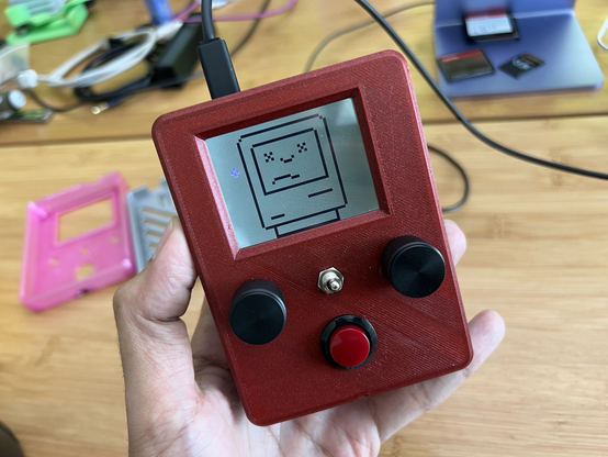 3d printed enclosure featuring a display screen with a low resolution sketch of an apple macintosh inspired icon with a sad face also referred as the sad mac icon
