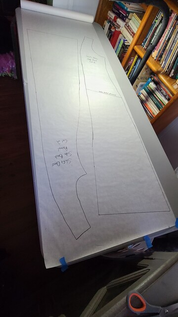 Outlines of side front and back dress pattern pieces on pattern paper ready to be cut out. 