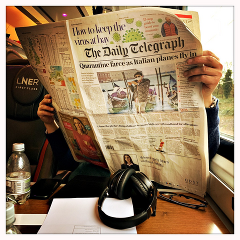 Someone reading the broadsheet newspaper, The Daily Telegraph. The headline is: “Quarantine farce as Italian planes fly in”. The date is 9 March 2020.