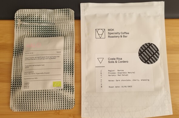 Two empty specialty coffee bags. One from Coffee Collective and the other from MOK
