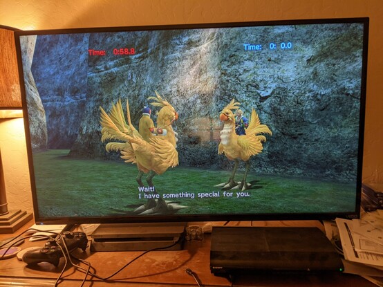 Two racers, the player and a trainer, are mounted on yellow chocobos, facing each other at the end of a race. The player's overall time is 0.0 seconds. The trainer says, "Wait! I have something for you."