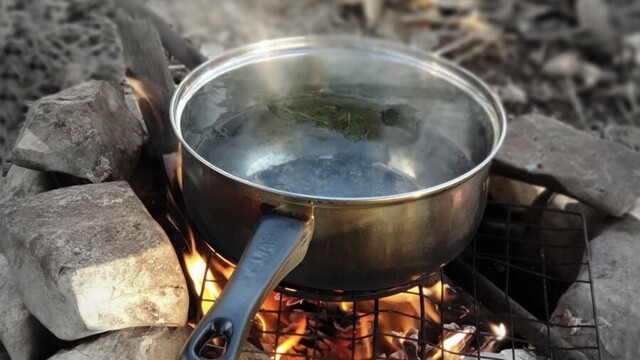Pot of boiling water on an open fire.