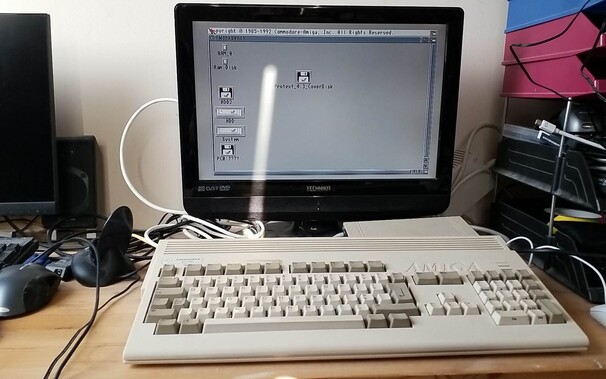 Commodore Amiga 1200 with TV running Workbench, sitting on desk.