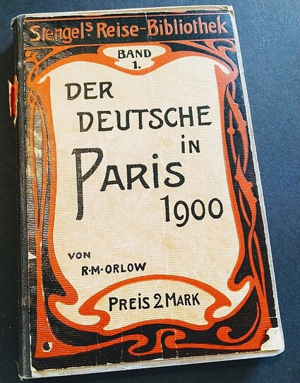 Abbildung des ReisefÃ¼hrers: R. M. Orlow: "Der Deutsche in Paris 1900", Berlin und Dresden 1900 (Stengelâ€™s Reise-Bibliothek, 1). Der Buchdeckel ist im Jugendstil gestaltet mit einer zeittypischen Schriftart und mit einem schwarz-roten Zierrahmen.