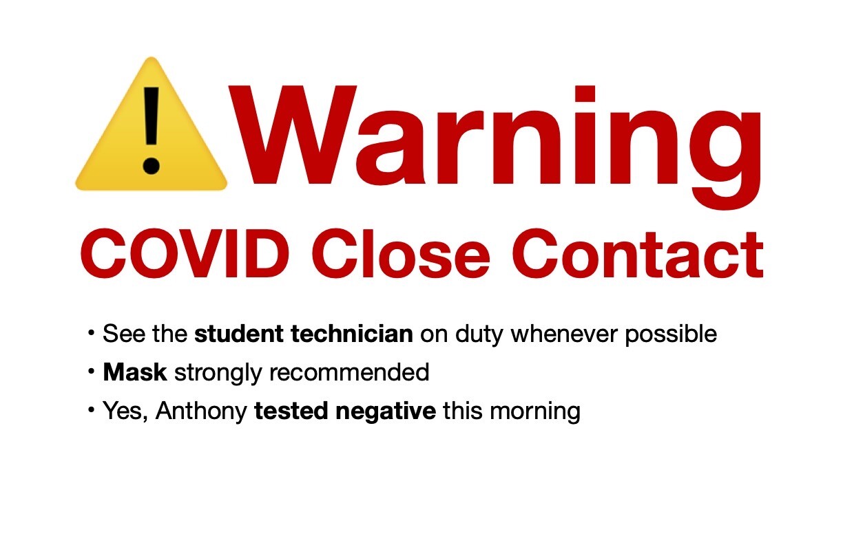 Sign reading:
⚠️Warning
COVID Close Contact
• See the student technician on duty whenever possible
• Mask strongly recommended
• Yes, Anthony tested negative this morning