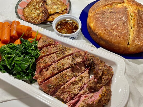 Ready to serve: the corned beef has been sliced up, ready to serve with potato pancakes called Boxty, whiskey-mustard dipping sauce, Irish soda bread, carrots and sautéed spinach on the side.