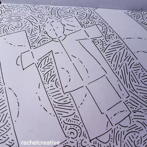 Art in progress. Ink on paper outlines a person with arms outstretched integrated into a striped pedestrian crossing on the ground. The road surface is heavily patterned, the white stripes intersected by a few spirals.