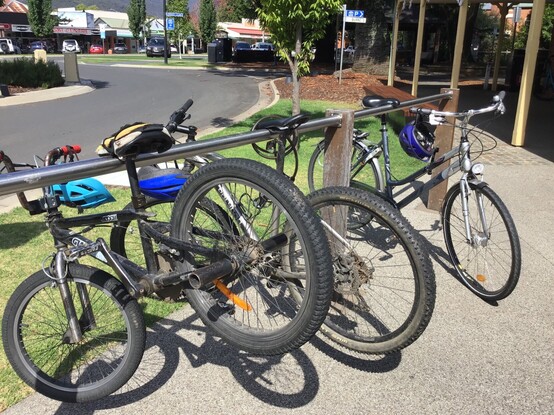 Bicycles on a rack where their seats are hooked over a bar and the whole bike is off the ground 
