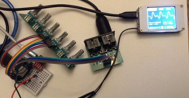 Photo of a Seeed XIAO SAMD21 on a mini solderless breadboard connected to a custom small PCB with six potentiometers mounted and a custom 3V3 MIDI module.  The output signal is displayed on a "mini DSO" type oscilloscope showing a FM modulated sine wave
