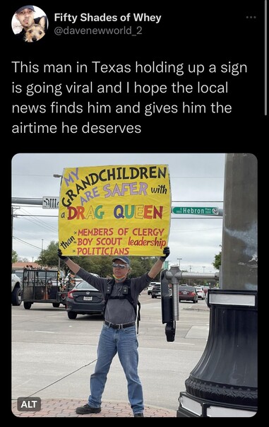 Tweet from @davenewworld_2 that says “ this man in Texas, holding up a sign, is going viral, and I hope the local news find him and give him the air time he deserves.” The picture shows a man holding up a large sign at an intersection that says my grand children are safer with drag queens than with members of the clergy, Boy Scout troop leaders, or politicians. 