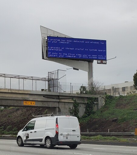 A digital billboard with a legacy Windows 2000 Embedded blue screen of death on it on the side of the 405 in California 