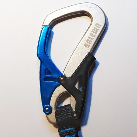 Ein blau-silberner Karabinerhaken eines Klettersteig-Sets.