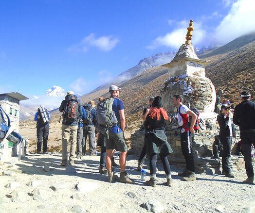 A group of trekkers standing in front of the old Stupa at Everest base camp