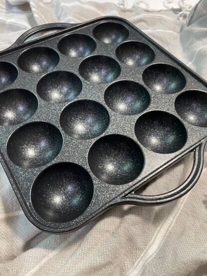 An aluminum ebelskiver pan: it has 16 holes for making toasted treats, either savory or sweet. 