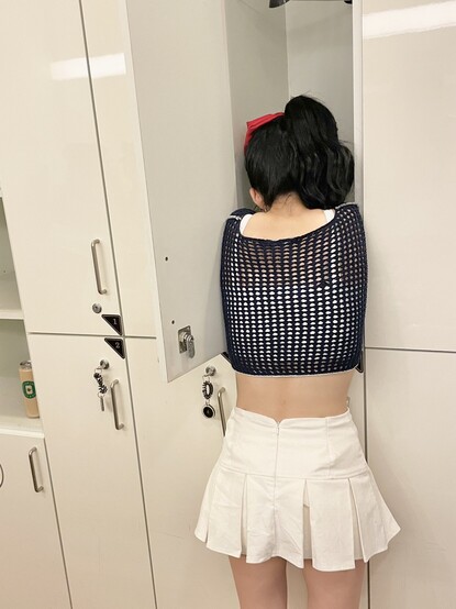 shot of ChaeY's back as she is almost crawling into a cupboard while taking a selfie. 