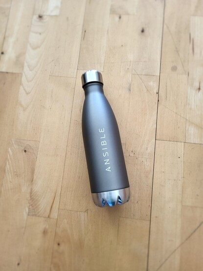 Picture shows a metallic drinking bottle with #Ansible logo
