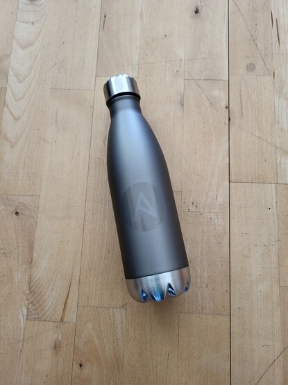 Picture shows a metallic drinking bottle with #Ansible logo