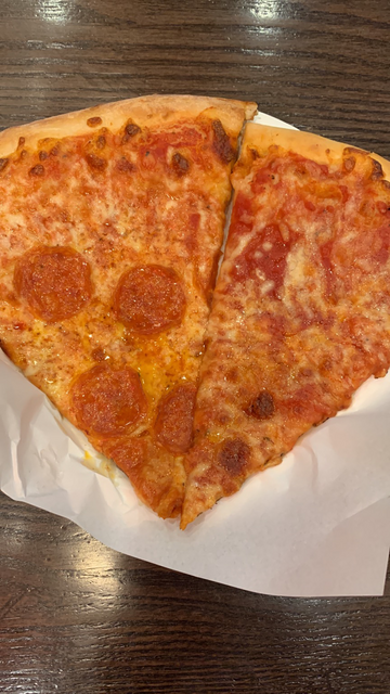 2 pizza slices: left side pepperoni, right cheese. Nice golden colours. Not too much toppings.