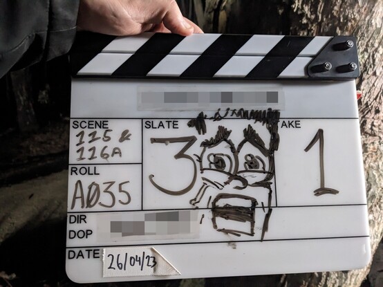A film slate showing slate 300, with a scared face who's eyes make up the zeros