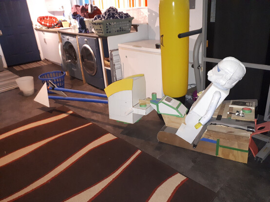 A 3ft tall lego person, made out of cardboard and flooring foam, sits on a construction of wood, cardboard and plastic pipes. If you didn't examine it too carefully, it might resemble a lego speeder bike, but a lot more work would be needed to convince most people.