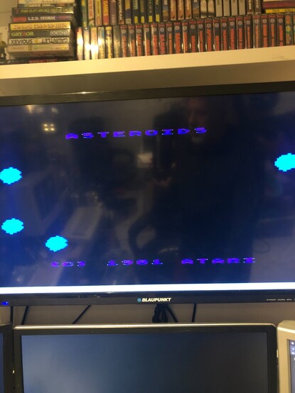 A photo of a modern flat screen TV showing the Atari Asteroids game attract screen, with a 1981 copyright statement.