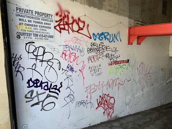 A parking garage wall covered in tags.