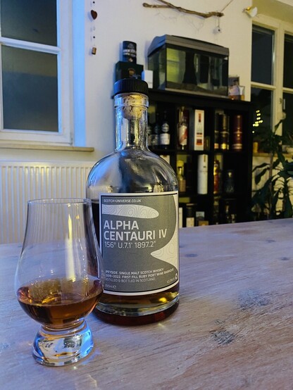 Bottle and a Glass of whisky with a very Dark Colour. 
