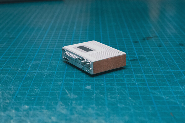 Miniature 1:12 scale VCR, view from the side at 45 degree angle, on top of a green desk mat
