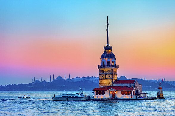 The Maiden Tower, also known as Leander Tower (Tower of Leandros) at twilight in city of Istanbul, Turkey. Located on a small islet at the southern entrance of the Bosphorus Strait. Great view of this iconic landmark is from the Uskadar district when you can also see minarets of the Blue Mosque and the Hagia Sophia in the background as in this image. 