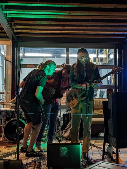 La banda toca la música, es el solo de la guitarra baja