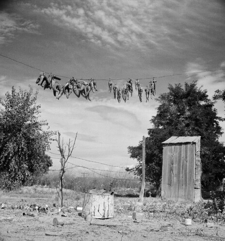 Photographing in New Mexico in 1941, Barbara Wright captured strings of peppers drying high on a line. Nearby are an outhouse and discarded cans on the ground.