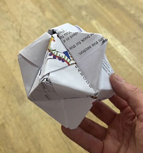 Spherical-ish cumulated octahedron made from 12 interlocking pieces of folded paper - in this case, dismembered exam paper