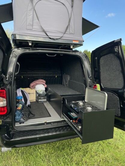 Cargo hold of a Citroen Berlingo van after it’s been sound proofed, ply lined, carpeted and with additional storage.
