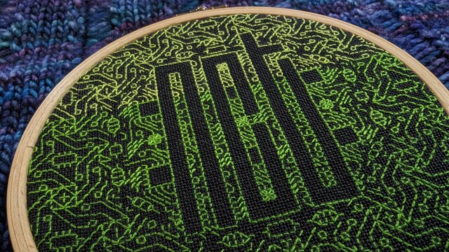 Another perspective of the gradient green embroidered NCT against black linen.