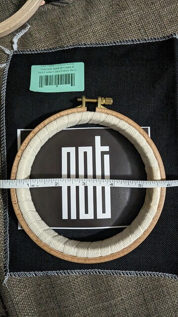 A Nurge No. 2 hoop with the printed NCT logo on paper and a measuring tape across the hoop to get a perspective on what the project would look like.