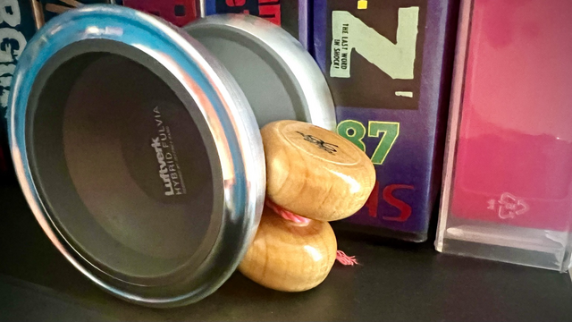 Gray hybrid fluvia set up for freehand play. Wooden lil bleeb counterweight. VHS tapes in the background. 