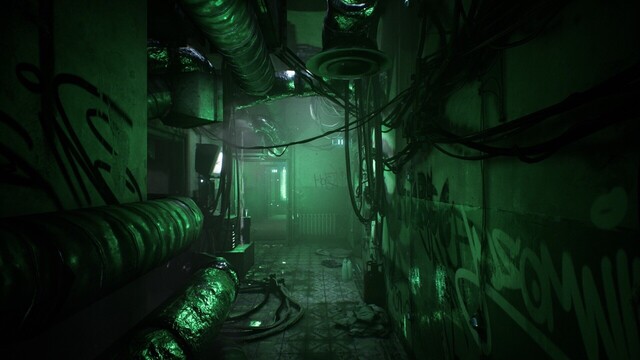 A hallway in an apartment complex cluttered with pipes and power lines. There is graffiti on the walls, the floor is tiled.