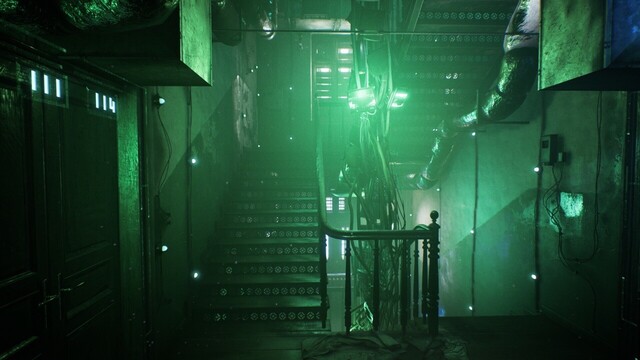 A stairwell in an apartment complex with power lines snaking through it. There are glowing lamps on many of the pipes and walls.