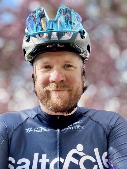 A happy cyclist with cherry blossoms in the background