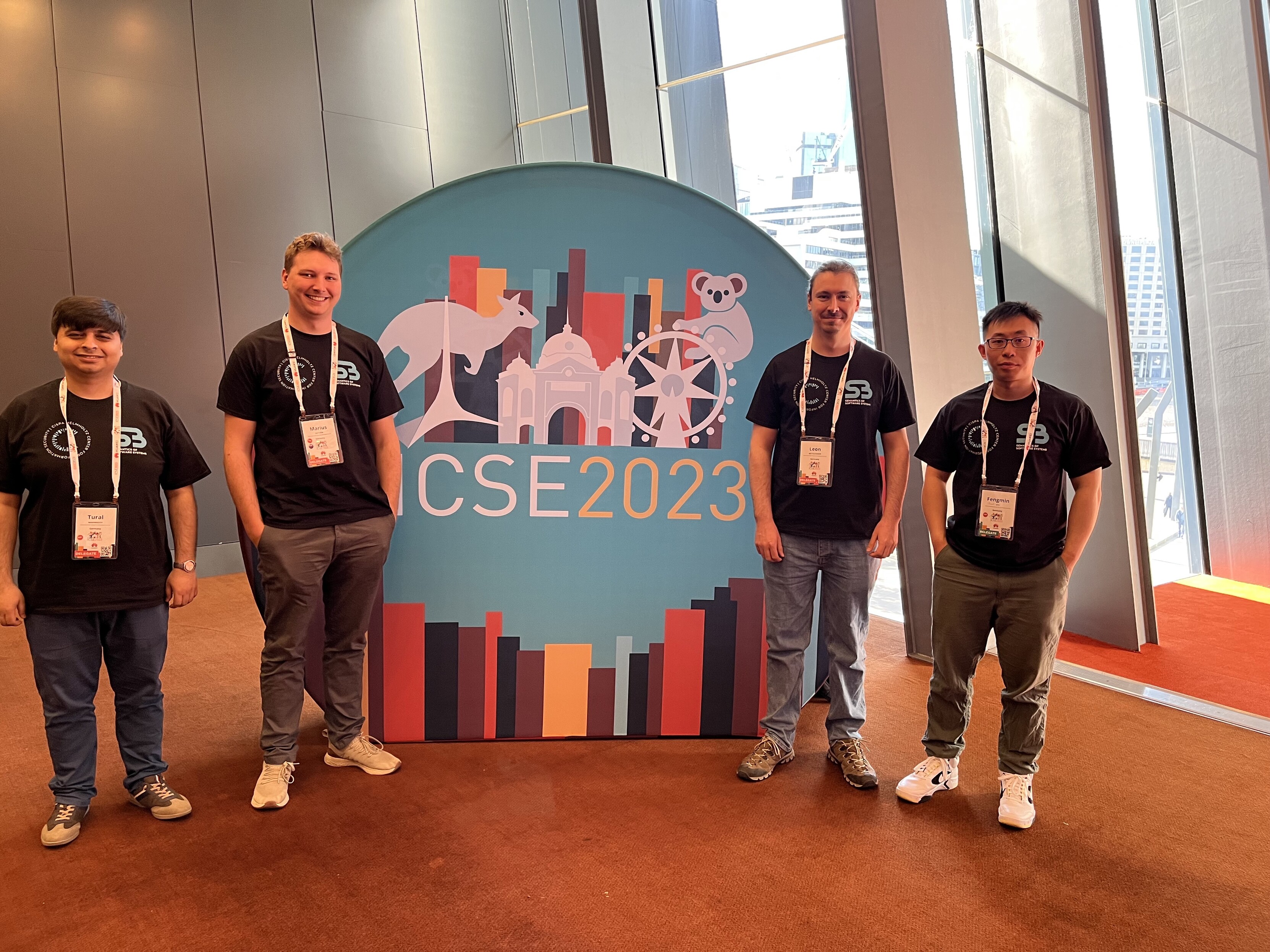 Tural Mammadov, Marius Smytzek, Leon Bettscheider, and Fengmin "Paul" Zhu at ICSE wearing a T-Shirt on which Andreas Zeller advertises Post-Doc positions