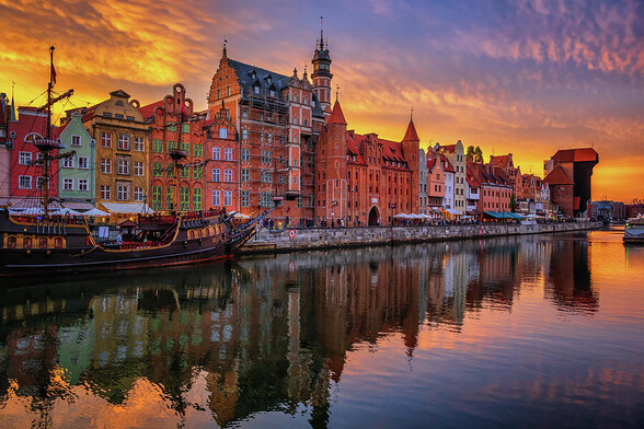 City of Gdansk at dusk in Poland. Skyline of the Old Town along Long Embankment and reflection in the Motlawa River. 