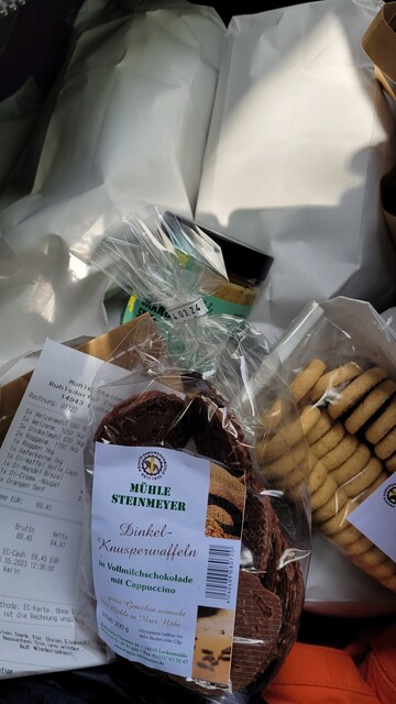 Foto: Blick in die Fahrradpacktasche mit Mehlsäcken und - tüten, außerdem zwei Packungen Kekse und ein Glas Senf. 