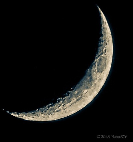 Photograph of the crescent moon in twilight. The photo is black and white. 

Aufnahme der Mondsichel in der Dämmerung. Das Foto ist schwarz-weiß. 